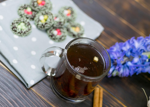 Una taza con té de hierbas y galletas sobre un fondo oscuro