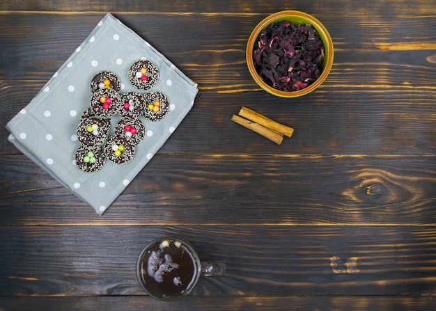 Una taza con té de hierbas y galletas sobre un fondo oscuro