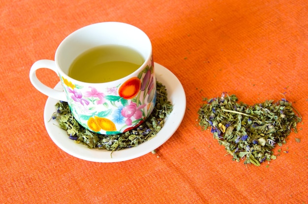 Foto taza de té de hierbas de malva sobre fondo naranja