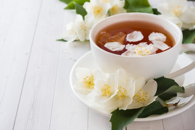 Taza de té de hierbas con pétalos de flores de jazmín.