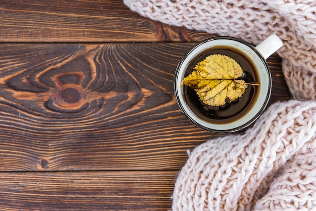 Taza de té y hojas de arce otoñal