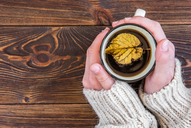 Taza de té y hojas de arce otoñal