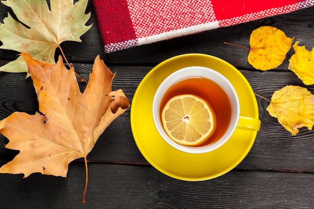 Taza de té y hojas de otoño sobre la mesa