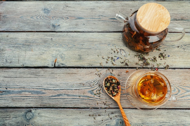 Taza de té y hojas de té en el fondo de la mesa de madera