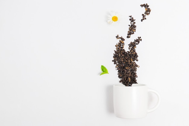 Taza de té y hojas de té rojas dispersas en forma de vapor Maqueta con espacio de copia de composición de té y taza de té premium y espacio vacío para texto fondo blanco buenos días y concepto de pausa para el té