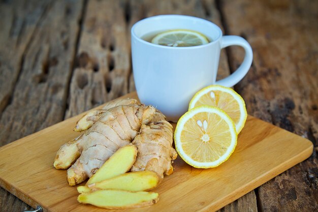 Taza de té de jengibre con limón en madera