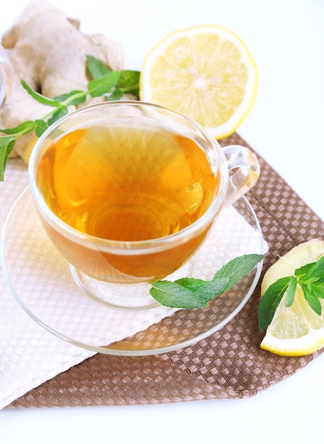 Taza de té con jengibre en servilleta aislado en blanco