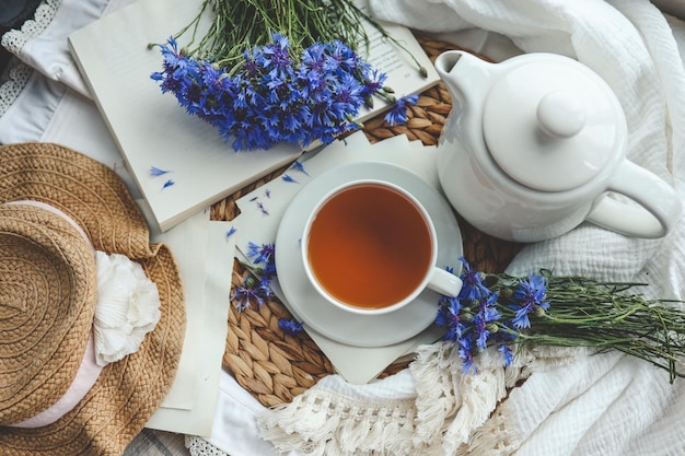 Taza de té libro abierto y vista superior de acianos