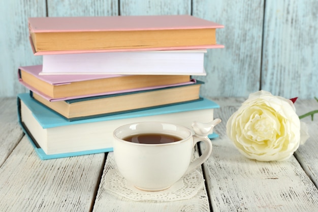 Taza de té con libros sobre la mesa de madera