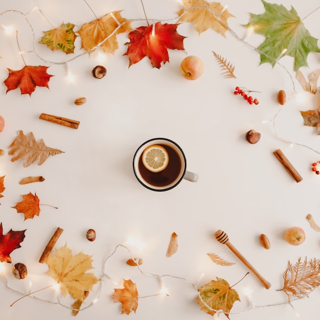 Taza de té de limón en el marco de hojas de color naranja y rojo creativo patrón de otoño postal copia espacio vista superior