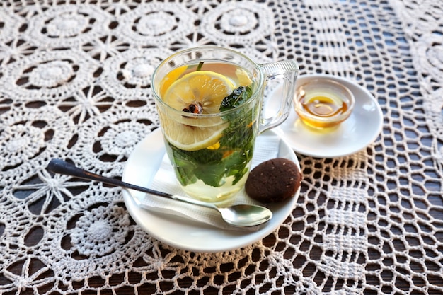 Taza de té con limón, menta, jengibre y postre.