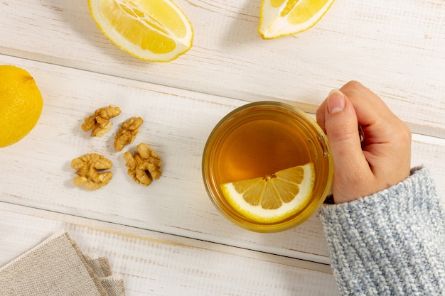 Taza de té con limón en la mesa de madera blanca