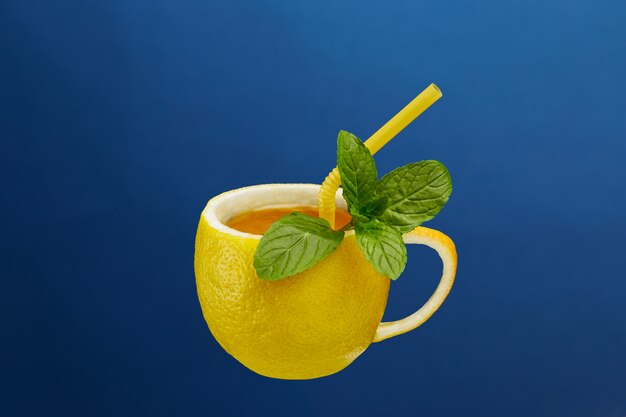 Una taza de té de limón natural con hojas de menta. Composición creativa sobre el tema del té natural.