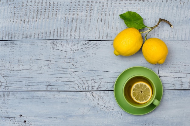 Taza de té y limones maduros