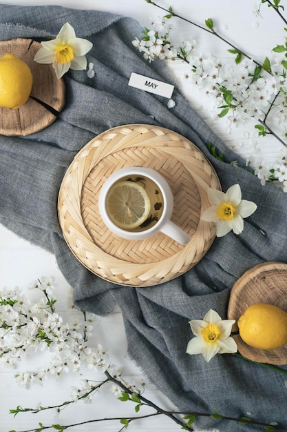 Una taza de té con limones en una mesa