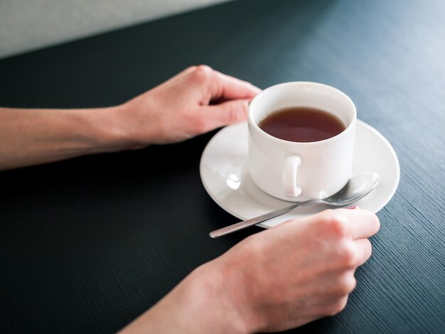 Foto taza de té de la mañana en manos de una mujer joven