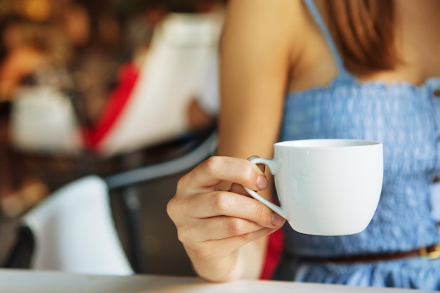 Taza de té en mano de mujer en el interior del restaurante