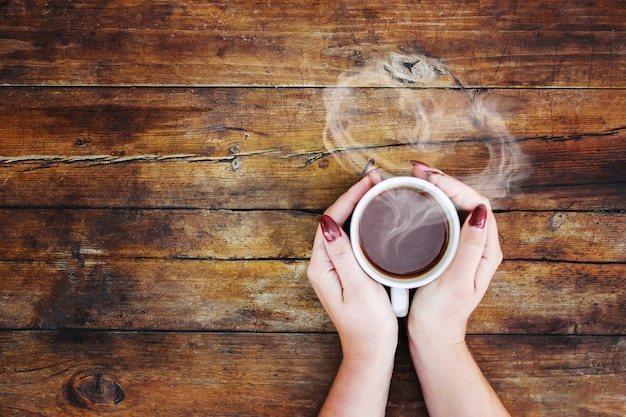 Una taza de té en las manos. Enfoque selectivo