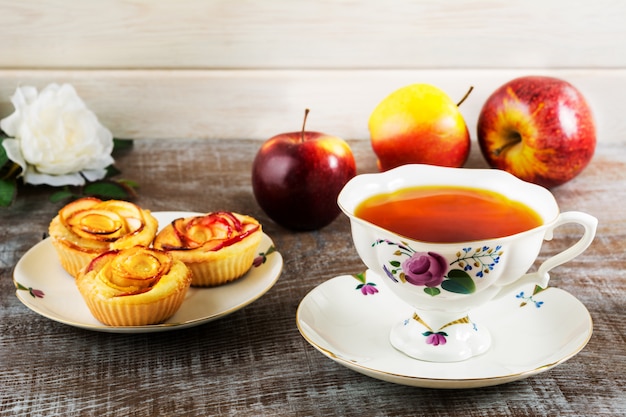 Taza de té y manzana magdalenas en forma de rosa