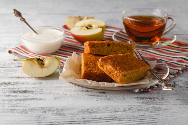 Taza de té de manzana en un plato de vidrio