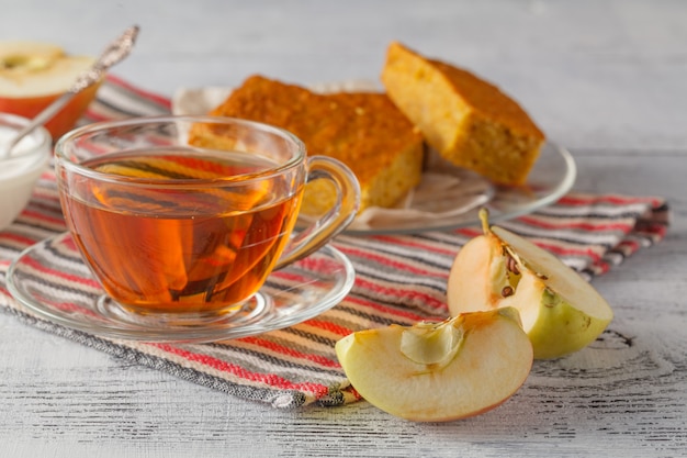 Taza de té de manzana en un plato de vidrio