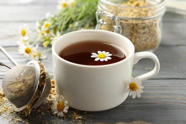 Taza de té de manzanilla en la mesa de madera