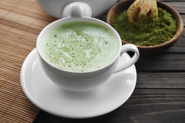 Taza de té matcha fresco sobre fondo de madera