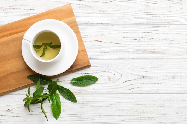 Taza de té de menta en el fondo de la mesa Té verde con vista superior de menta fresca con espacio de copia