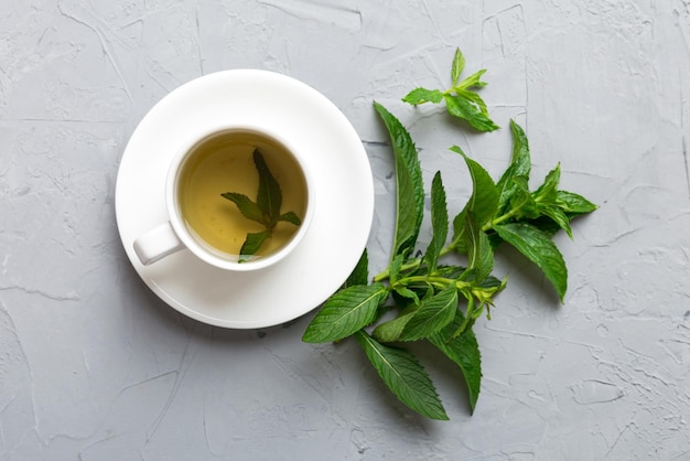 Taza de té de menta en el fondo de la mesa Té verde con vista superior de menta fresca con espacio de copia