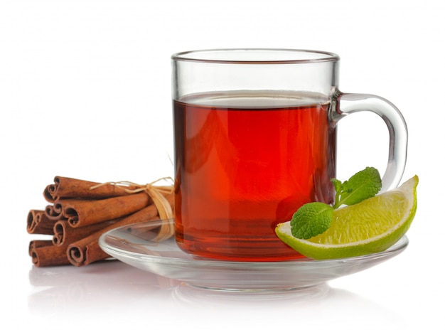 Taza de té con menta fresca, limón y canela aislados en blanco
