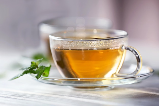 Taza de té con menta en mesa de madera