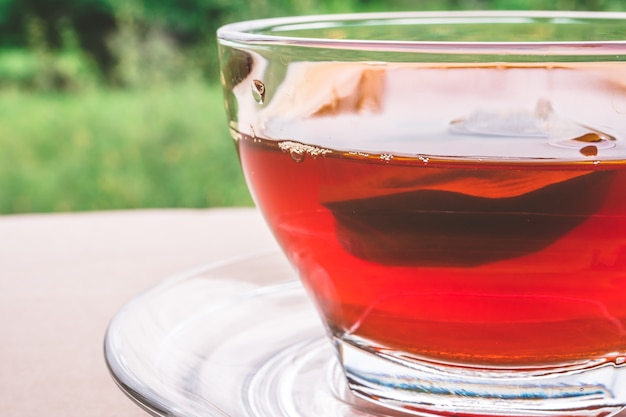Foto una taza de té en la mesa de madera, bolsita de té en el vidrio, fondo de la naturaleza.