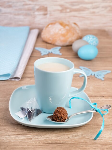 Taza de té en la mesa de madera con decoraciones de Pascua