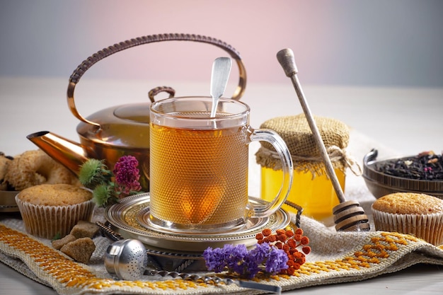 Una taza de té con miel y una cuchara con una flor