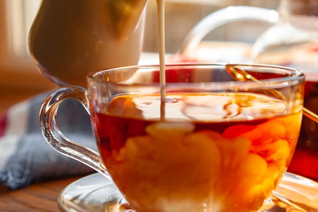 Taza de té negro caliente de cerca en la mesa de madera