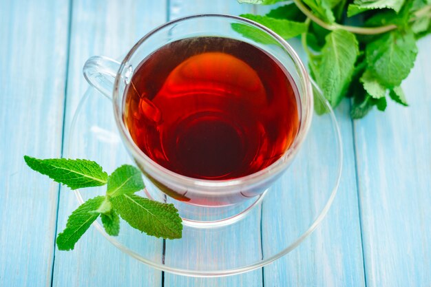 Taza de té negro con hojas de menta