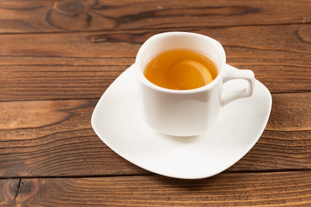 Taza de té negro en mesa de madera