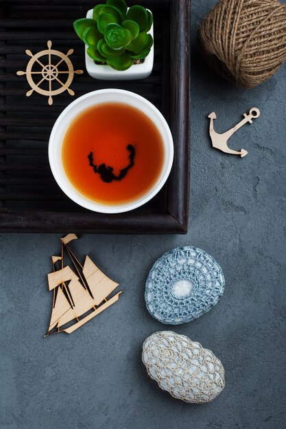 Taza de té negro y piedras de ganchillo