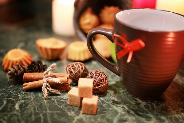 Taza de té de noche con vela y manzana.