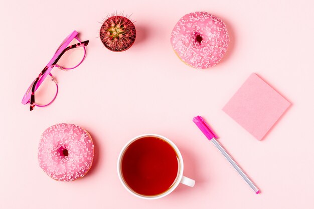 Taza de té con nueces doand sobre un fondo rosa pastel