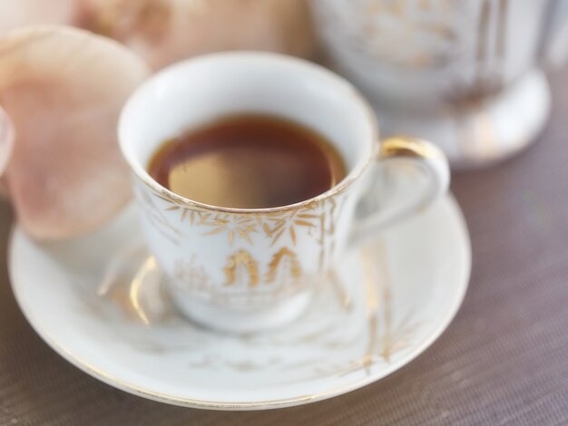 Taza de té o café y flores de orquídeas.