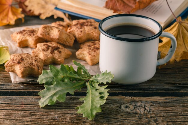 Taza de té o café con hojas de otoño y galletas. Estacional, hora del té, concepto de naturaleza muerta.