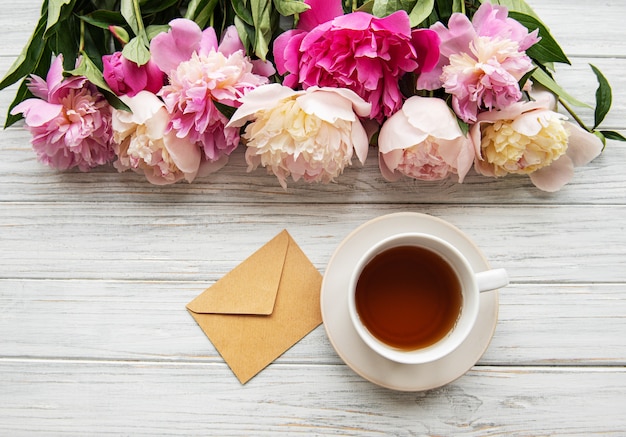 Taza de té y peonías rosas