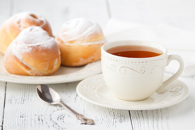 Taza de té y pequeños pasteles en forma de rosas de manzana. Tarta de postre dulce de manzana