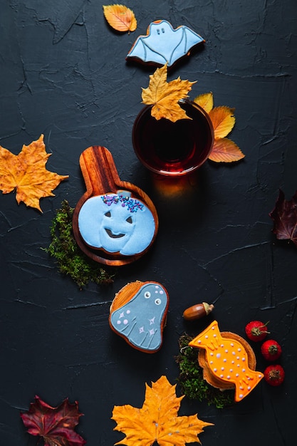 Taza de té pintadas de bellotas de pan de jengibre y hojas sobre un fondo negro