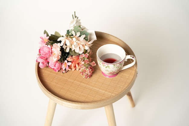 Foto taza de té y un ramo de flores en la mesa de madera