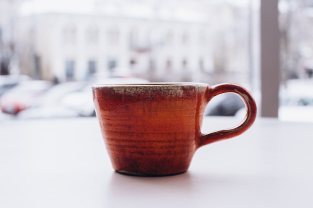 Taza de té retro naranja en ventana