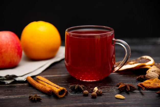 Una taza de té rojo afrutado sobre un fondo de madera