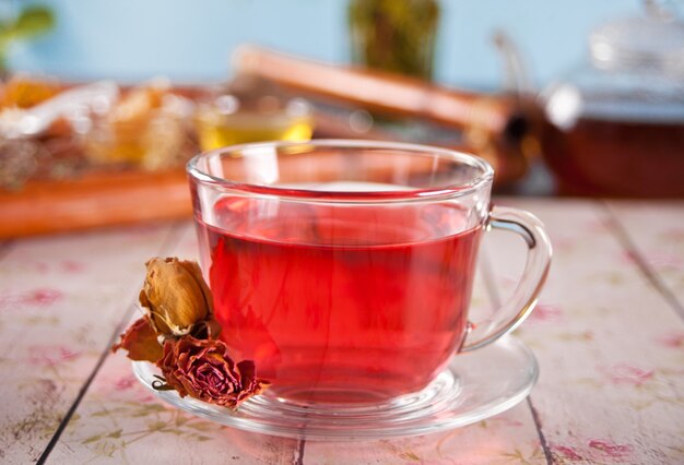 Taza de té rojo de hierbas con rosas secas de hibisco