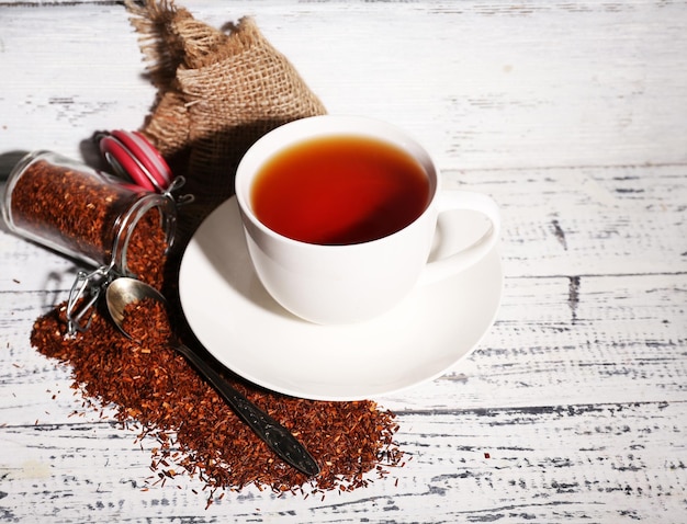 Una taza de té rooibos sabroso en una vieja mesa de madera blanca